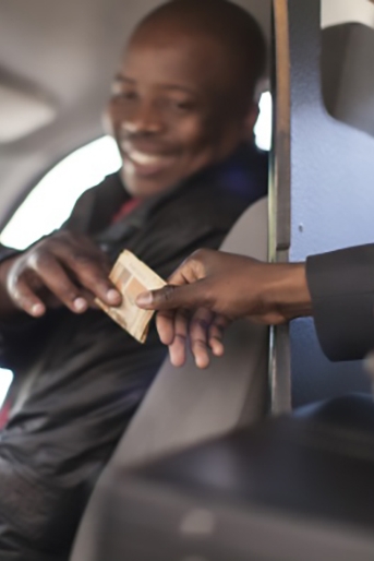 Photo of a customer handing a cash tip to an appreciative taxi driver
