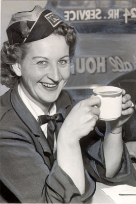 A uniformed woman taxi driver smiles at the camera in 1958