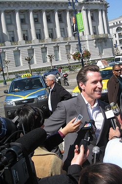 Photo of San Francisco Mayor Gavin Newsom hamming it up for reporters at a taxi-related press conference in front of City Hall